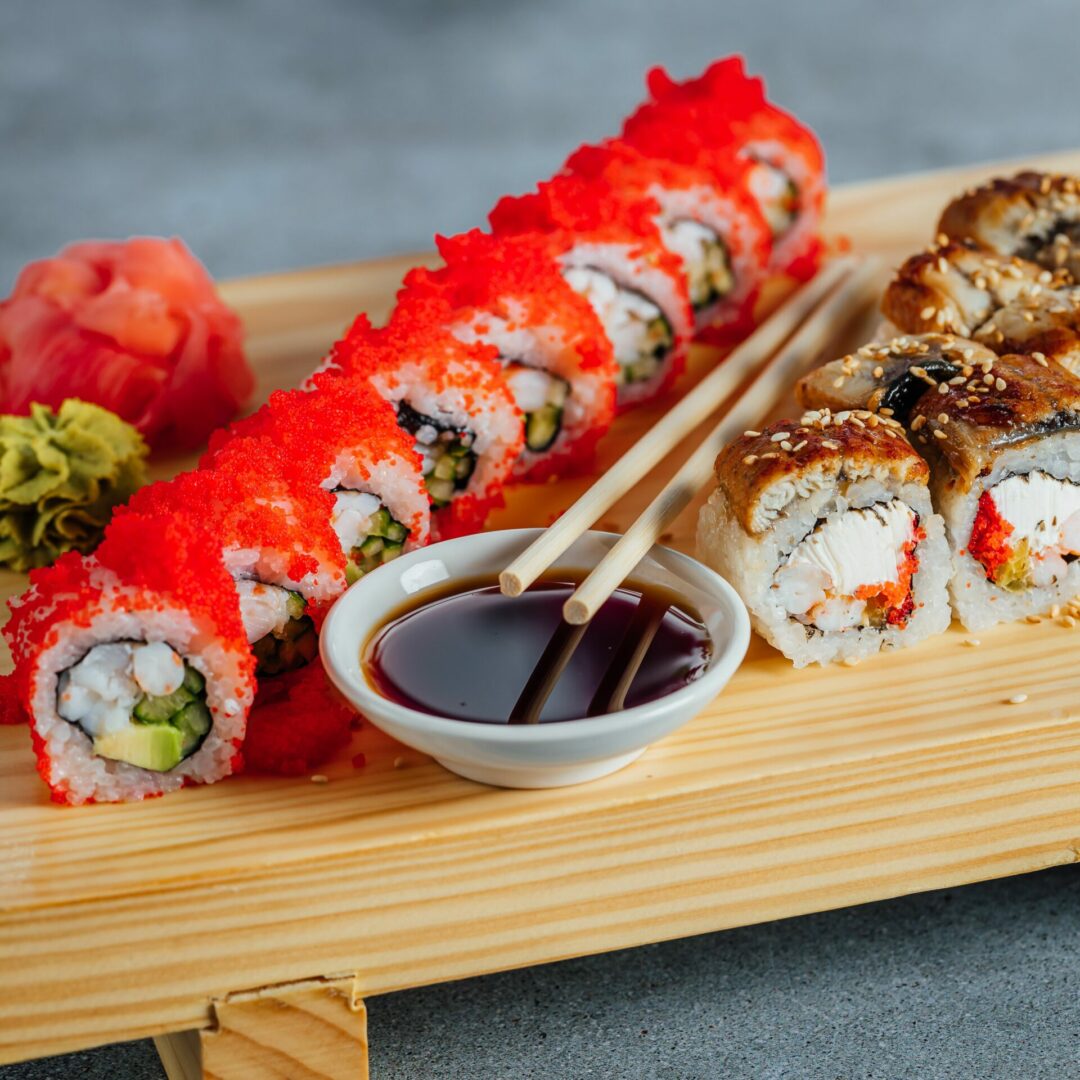 Sushi rolls served on a wooden tray alongside two chopsticks